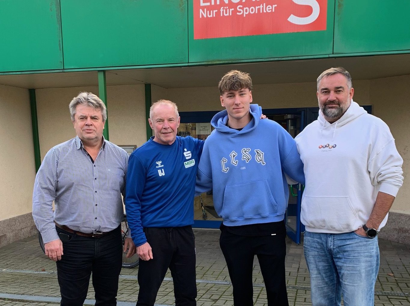 Geschäftsführer Rüdiger Jurke, Cheftrainer Uwe Jungandreas, Paul Bones und Sportlicher Leiter des EHV Aue Stephan Swat nach Vertragsschluss vor der Erzgebirgshalle